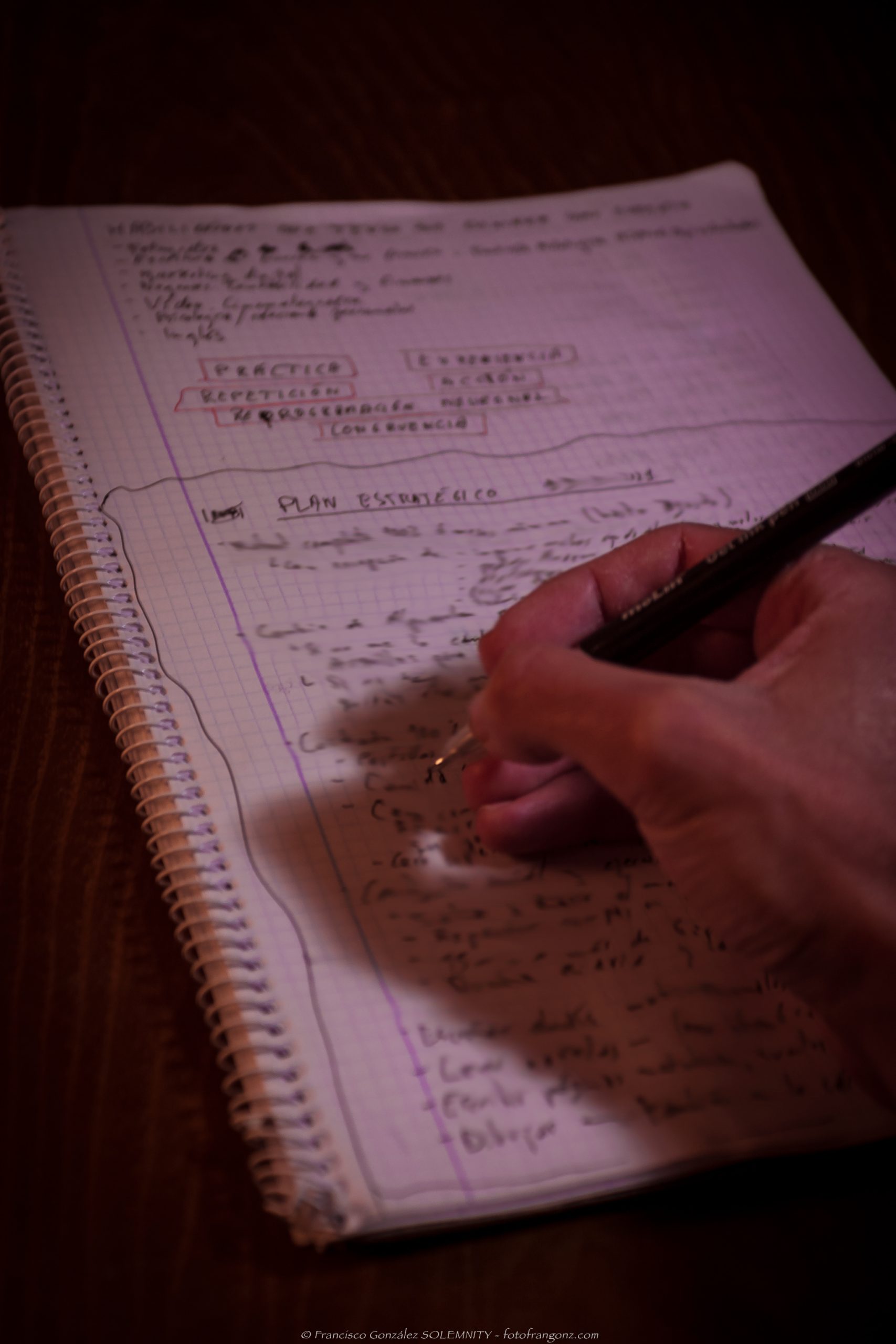 Escribiendo en una libreta con un bolígrafo un plan de contenidos estratégico